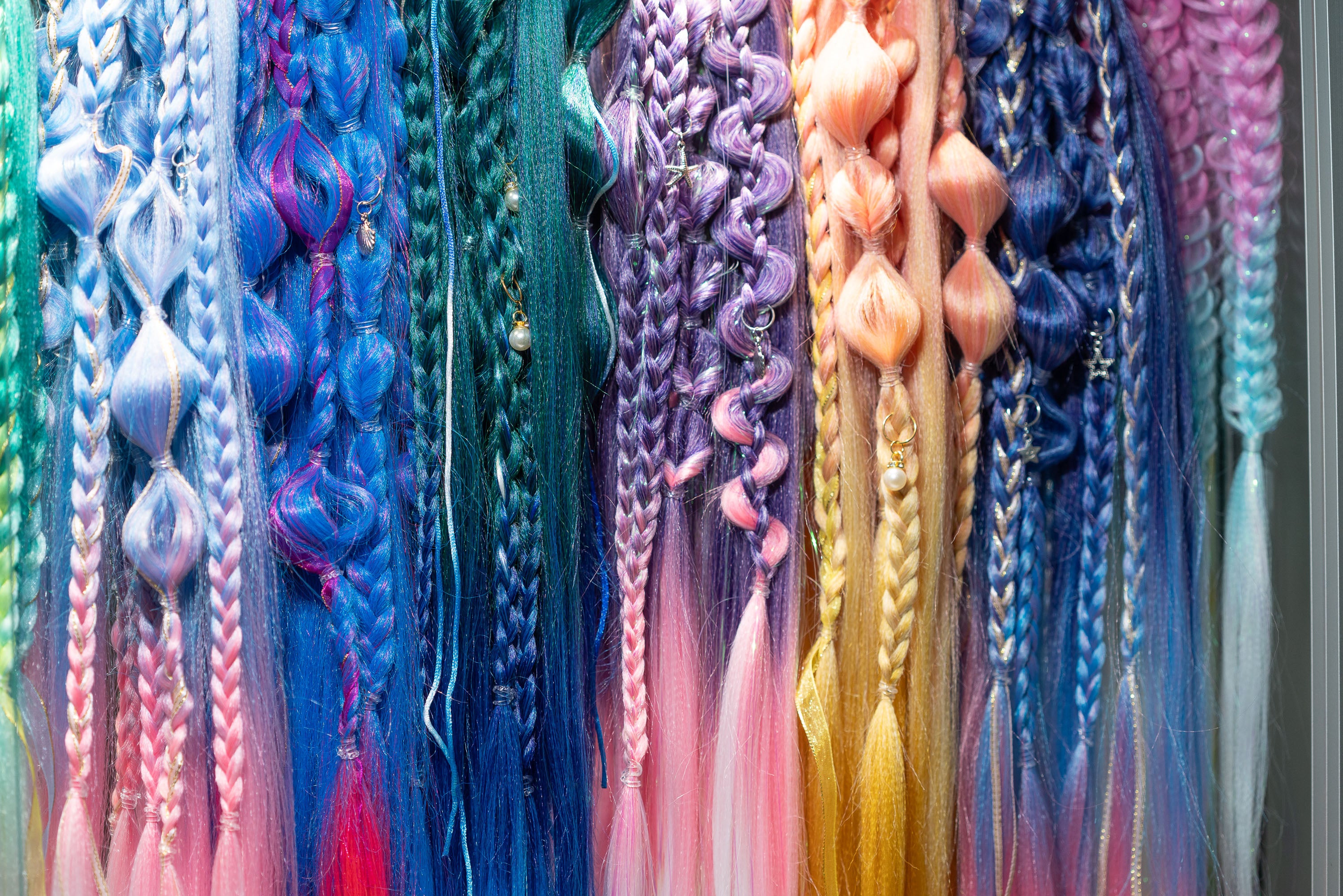 Colorful braided hair extensions displayed against a neutral background for parties