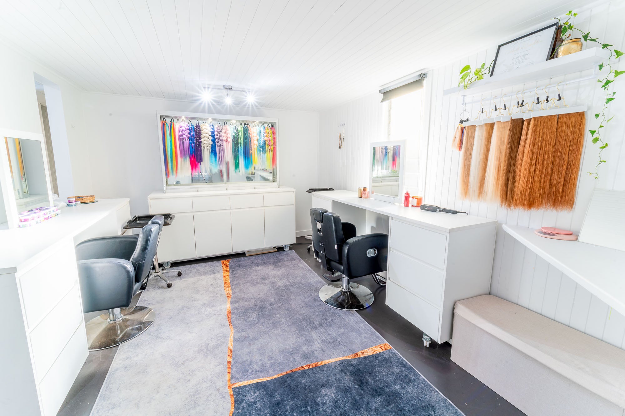 Salon interior with styling chairs, mirrors, and hair color samples.